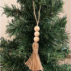 an ornament hanging from the top of a christmas tree with balls and tassels