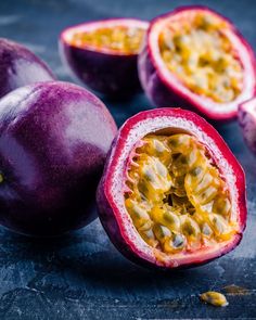 passion fruit cut in half with the seeds still attached to it, on a dark surface