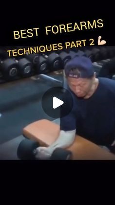 an old man sitting at a table in a gym with dumbbells on the floor