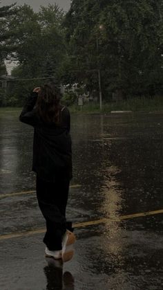 a person walking in the rain with an umbrella over their head and one foot up