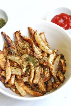 a white bowl filled with fried potatoes and herbs