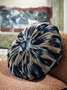 a brown and black pillow sitting on top of a chair