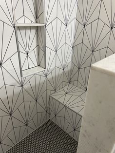 a bathroom with black and white tiles on the walls, flooring and shower stall