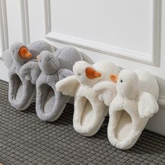 three pairs of slippers with an elephant and duck design on them sitting in front of a door