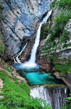 a small waterfall in the middle of a mountain