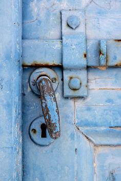 an old blue door with a rusted handle