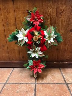 a bouquet of poinsettis and greenery on the floor