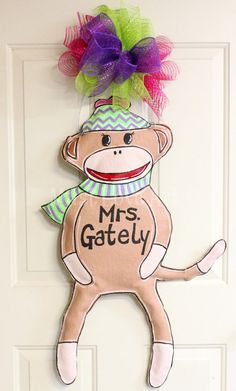 a door hanger with a sock monkey on it's head and the words mrs gately