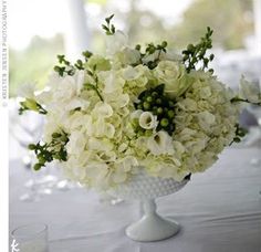 a vase filled with white flowers on top of a table