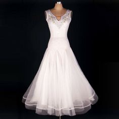 a white dress on a mannequin stand in front of a black background,