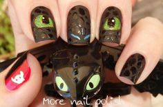 a person with black and green nail polish holding up a cat shaped manicure on their nails