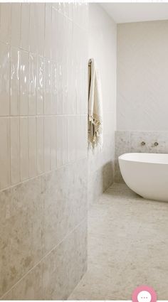 a white bath tub sitting next to a toilet in a bathroom