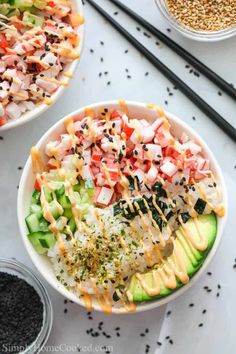 two bowls filled with different types of food and chopsticks next to each other