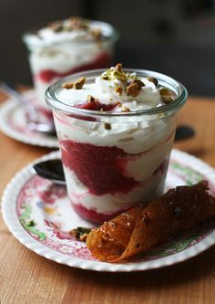 two desserts are sitting on a plate with spoons