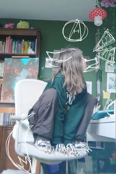 a woman sitting on top of a white chair in front of a book shelf filled with books