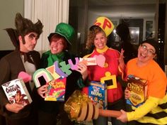 four people dressed up in costumes posing for the camera with some snacks and candy boxes