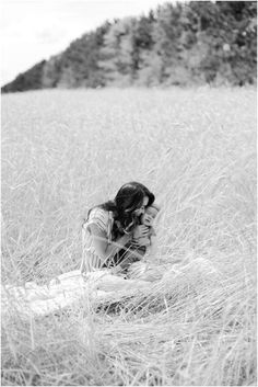 black and white photograph of a woman sitting in tall grass