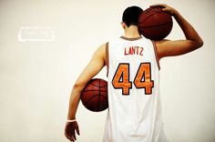 a man holding a basketball in his right hand and wearing a white jersey with the number 44 on it