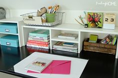 there is a desk with books and magazines on it, along with other office supplies