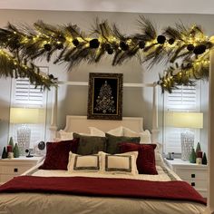 a bedroom decorated for christmas with pine cones and garland on the headboard, lights strung over the bed