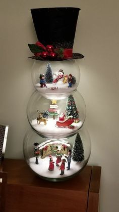 three snow globes with christmas decorations in them