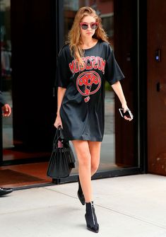 a woman is walking down the street with her handbag