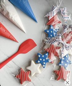 red, white and blue decorated cookies in cellophane bags with plastic spoons