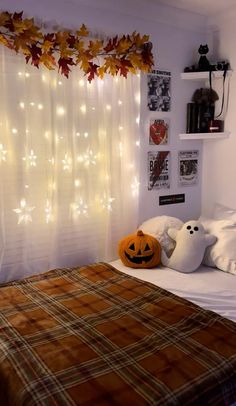 a bedroom decorated for halloween with pumpkins and lights