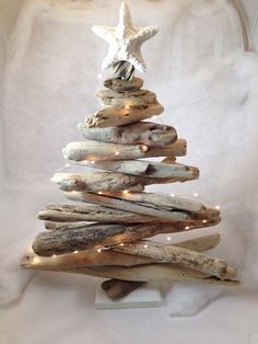 a christmas tree made out of driftwood with lights on the top and a starfish