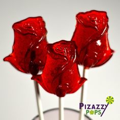 two red lollipops sitting on top of each other in a glass vase