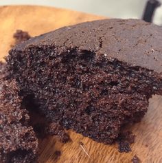 a piece of chocolate cake sitting on top of a wooden cutting board