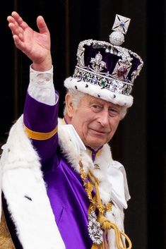 an older man wearing a crown waves to the crowd while holding his hand out in front of him