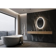 a bathroom with a large round mirror above the bathtub next to a wall mounted sink