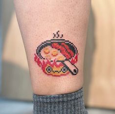 a woman's leg with a pixelated image of a hot dog and ketchup on it