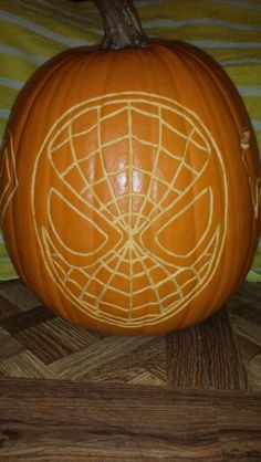 a pumpkin carved to look like a spiderman's web - net design on it