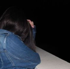 a woman sitting on top of a white table next to a cell phone in her hand