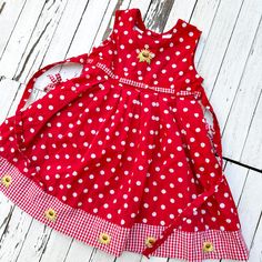 Designed for a toddler in size 4, this dress is crafted from 100% cotton for a soft and comfortable fit. It features delightful sunflower embroidery and charming gingham. Ideal for picnics, birthday parties, or any special occasion, this dress is as versatile as it is cute. Key Features: Size: Toddler 4 Material: 100% Cotton Color: Red and white polka dot with sunflower embroidery Details: Gingham trim  Style: Vintage-inspired, perfect for special occasions or everyday wear Condition: Pre-loved with gentle signs of wear, maintaining its vibrant charm Playful Cotton Dress For Picnic, Cute Cotton Dresses For Picnic, Red Cotton Dress For Picnic, Cute Cotton Gingham Dresses, Cute Polka Dot Cotton Dress, Cute Gingham Cotton Dress, Toddler Red Dress, Vintage Toddler Dress, Polka Dot Baby Dress