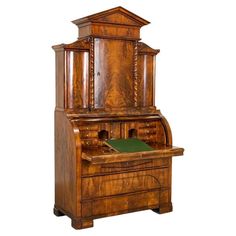 an old wooden desk with a green book on it's top and bottom shelf