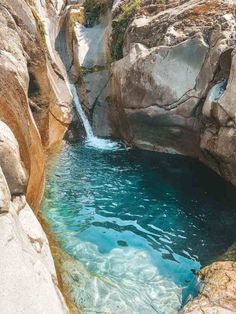 there is a pool in the middle of some rocks and water that is running down it