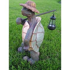 a statue of a turtle holding a golf club and wearing a hat on top of it's back