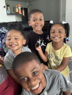 four children sitting on a couch smiling for the camera