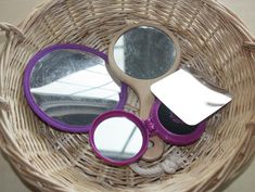 a wicker basket with some scissors and mirrors in it