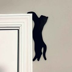 a black cat silhouette hanging on the side of a white door