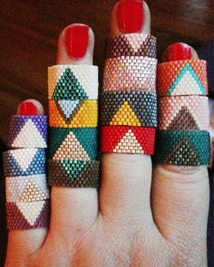 a woman's hand with five different colored rings on it