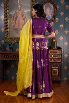 Purple lehenga with foil printed floral motifs and gota patti border. Comes with V neck blouse with lace trim and yellow dupatta.
Component: 3
Pattern: Print and Embroidery
Type Of Work: Foil Print, Gota Patti and Sequin
Neckline: V neck
Sleeve Type: Half
Fabric: Cotton Silk
Color: Purple
Other Details: 
Yellow dupatta with floral motifs and lace trim border
Sequin embroidered waistband
Occasion: Sangeet - Aza Fashions Designer Meenakari Chanderi Lehenga, Designer Banarasi Silk Lehenga With Gota Work, Gold Chanderi Sets With Motifs, Festive Purple Sets With Motifs, Semi-stitched Purple Lehenga With Motifs, Designer Purple Lehenga With Motifs, Purple Semi-stitched Sharara With Motifs, Semi-stitched Purple Sharara With Motifs, Unstitched Gold Lehenga With Meenakari Detail