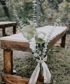 a wooden bench with flowers tied to it