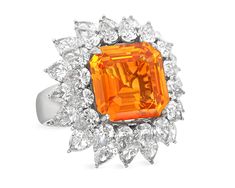 an orange and white diamond ring on a white background with the center stone surrounded by smaller diamonds