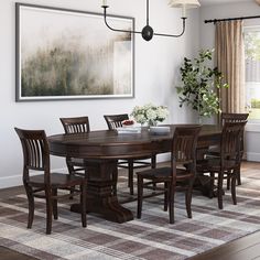 a dining room table with six chairs and a large painting on the wall above it