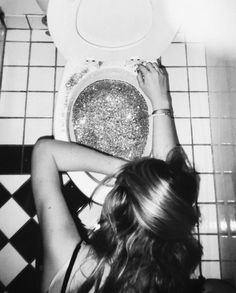 a woman sitting in front of a white toilet