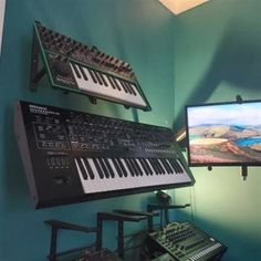 an electronic keyboard sitting on top of a table next to a monitor and other musical equipment